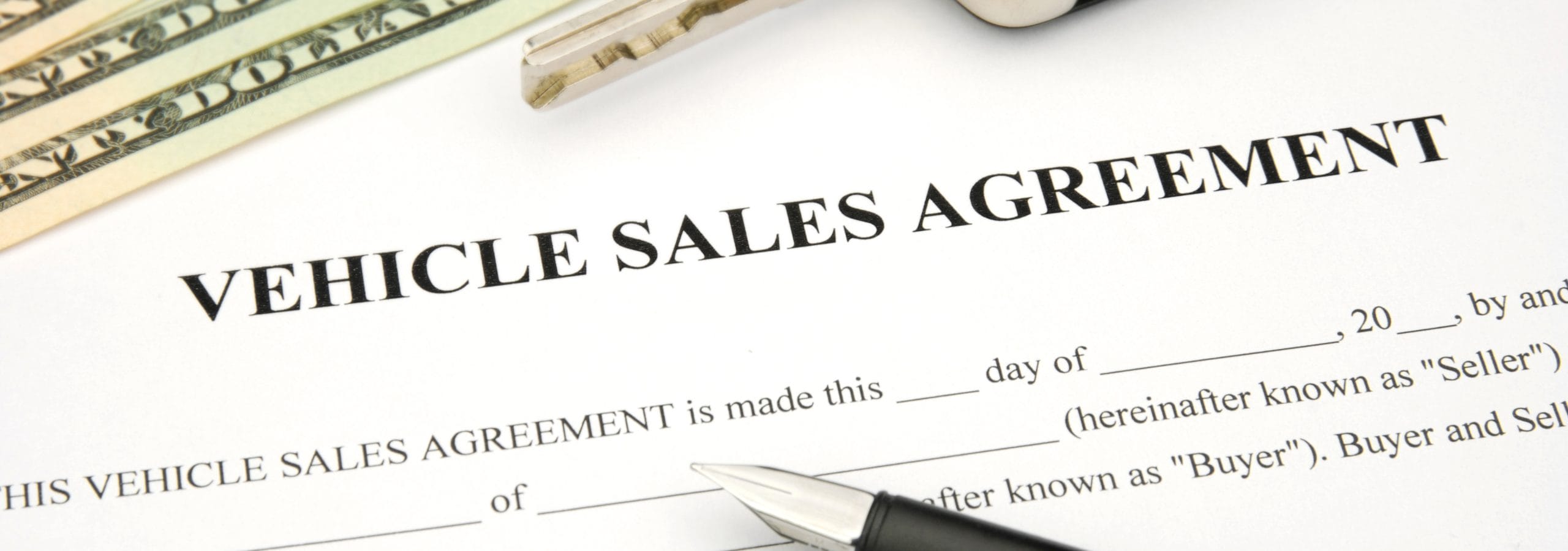Vehicle Sales Agreement with car key and money and document and pen